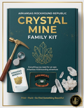 Arkansas Rockhound Republic Crystal Mine Family Kit with crystal, hammer, and magnifying glass on a green background